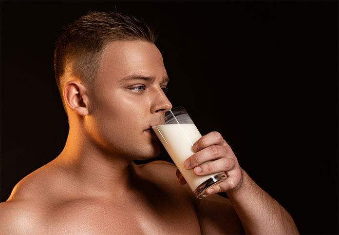 Junger blonder Mann trinkt Glas mit Sperma